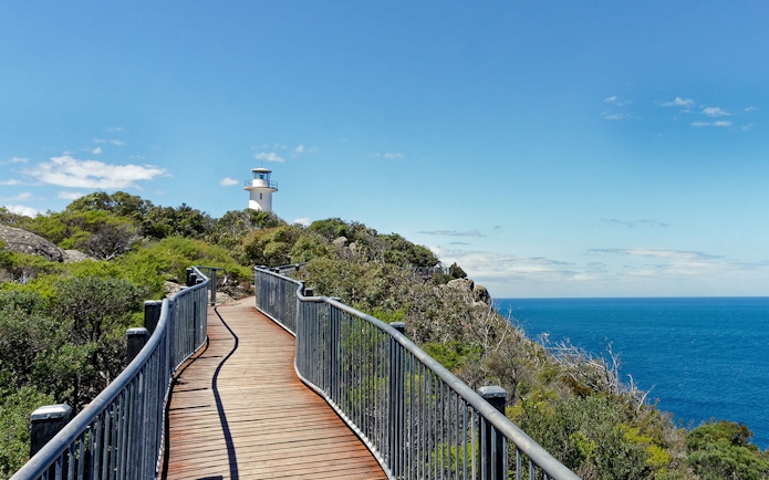 Coastal path leading to a lighthouse near Wineglass Bay, Tasmania.