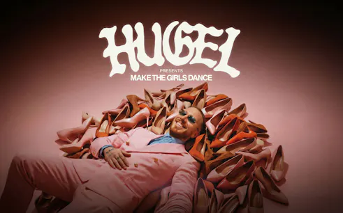 Hugel in pink suit surrounded by high heels, promoting "Make the Girls Dance" event in Ibiza.