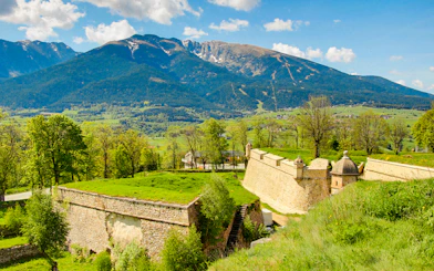 Forteresse de Montlouis with lush greenery and mountain backdrop in France.