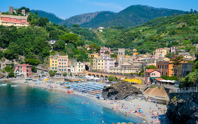 Monterosso beach with colorful buildings and hills in Cinque Terre, Italy.