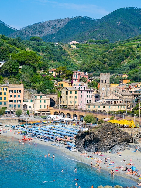 Monterosso beach with colorful buildings and hills in Cinque Terre, Italy.