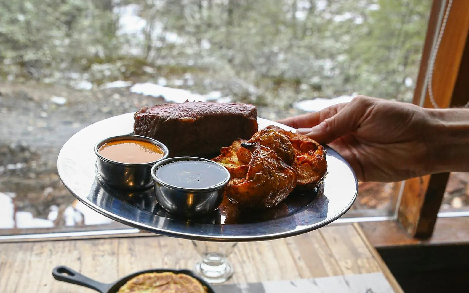 Grilled meat and roasted potatoes served with sauces during Snow and Fire Night experience.