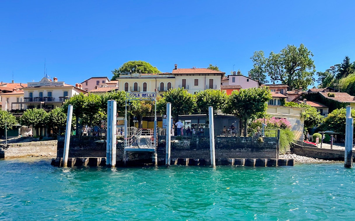 Isola Bella dock with buildings and trees, part of the Hop-on Hop-off Isole Borromee tour.