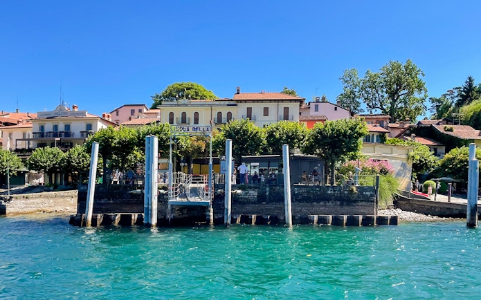 Isola Bella dock with buildings and trees, part of the Hop-on Hop-off Isole Borromee tour.