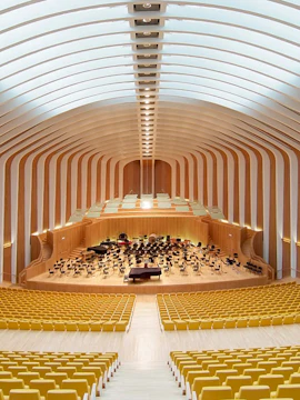 Interior of Palau de les Arts Reina Sofía concert hall with empty yellow seats and stage.