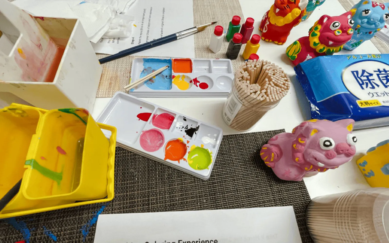 Paints and brushes for crafting Shisa figures at an Okinawan workshop.