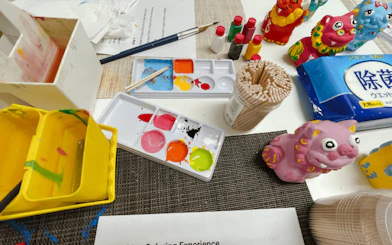 Paints and brushes for crafting Shisa figures at an Okinawan workshop.