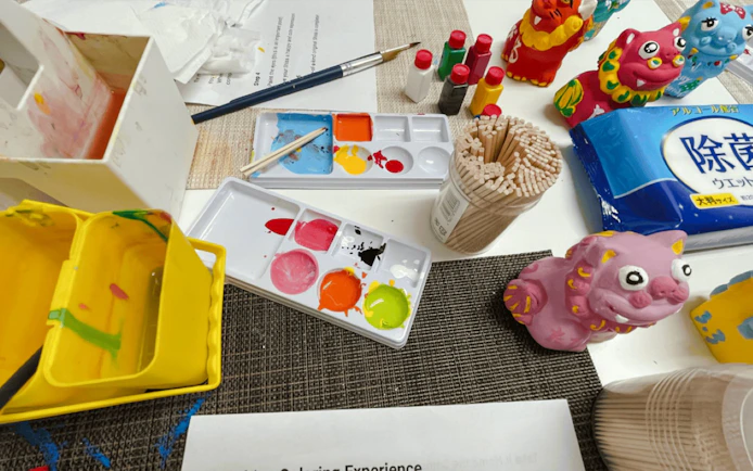 Paints and brushes for crafting Shisa figures at an Okinawan workshop.