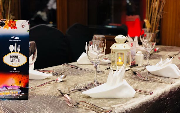 Dinner table setup on Marina Dinner Cruise with menu and candle lantern.