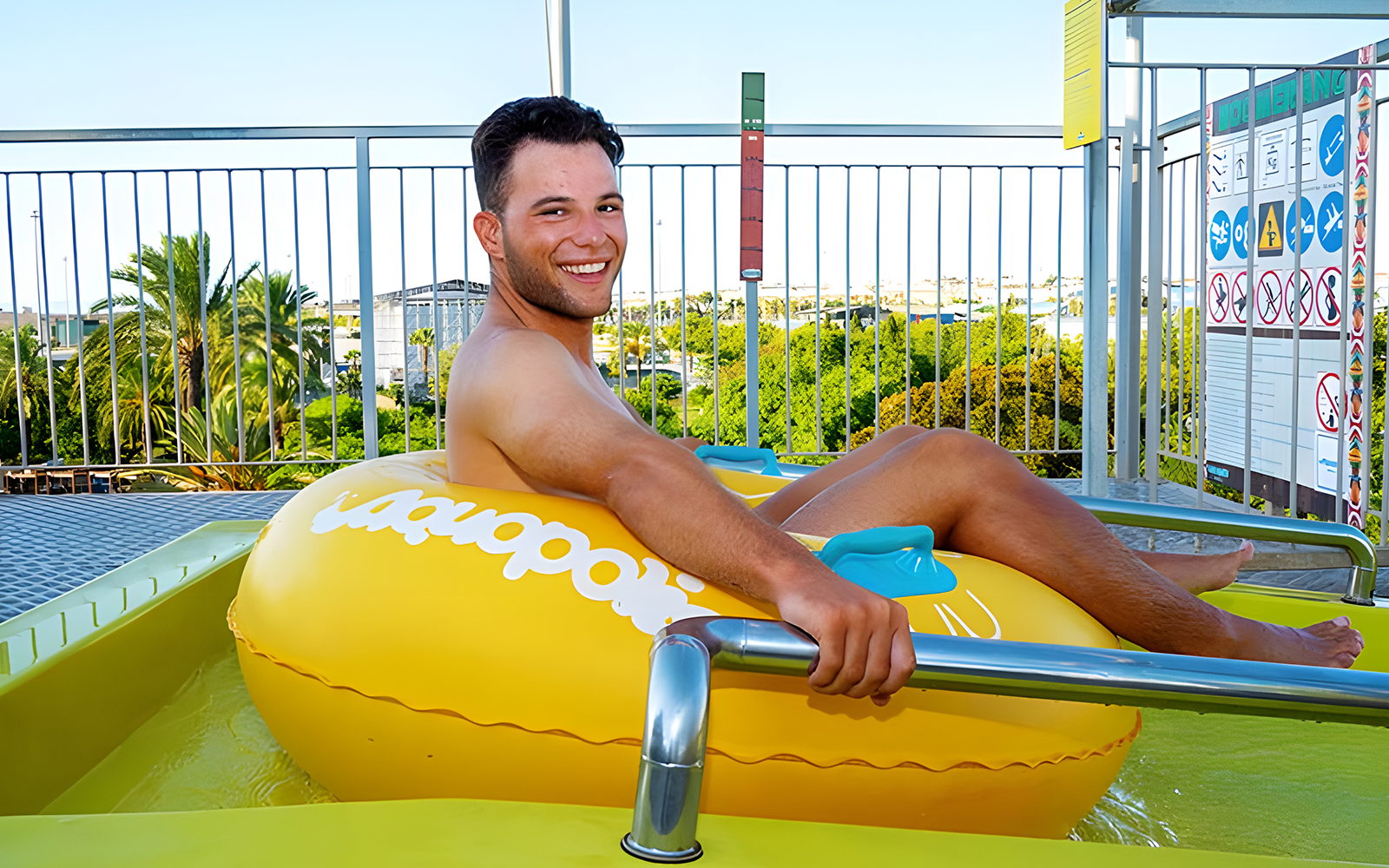 Person on a yellow inflatable at the Boomerang slide, Aquopolis Torrevieja.