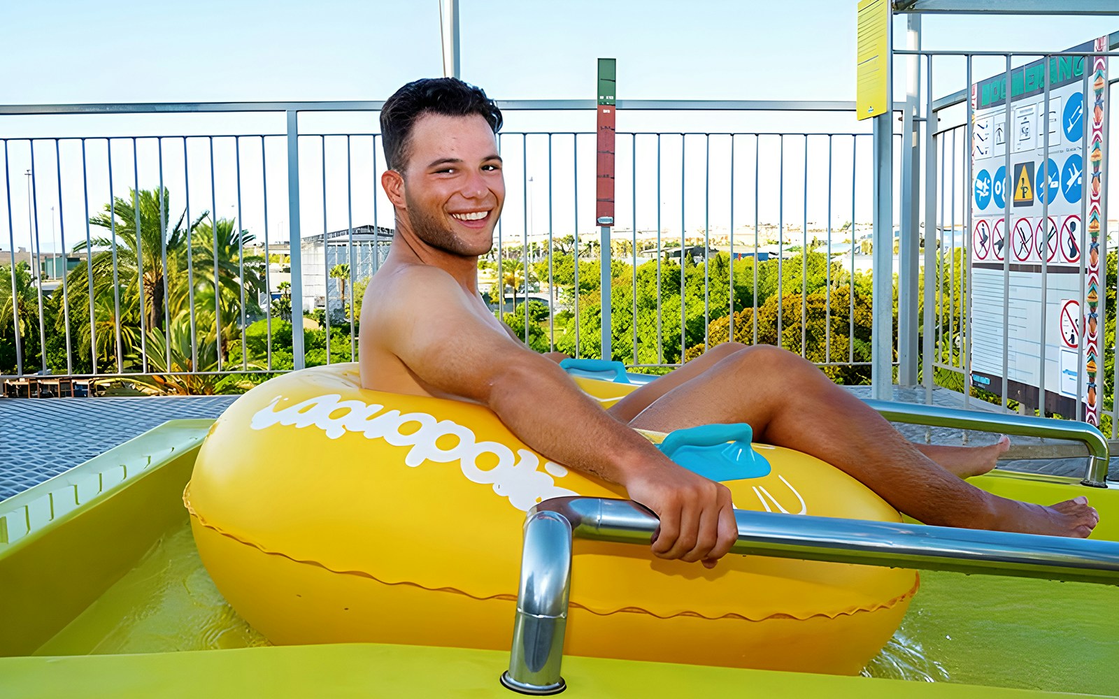 Person on a yellow inflatable at the Boomerang slide, Aquopolis Torrevieja.