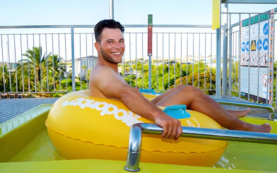 Person on a yellow inflatable at the Boomerang slide, Aquopolis Torrevieja.