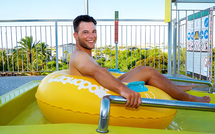 Person on a yellow inflatable at the Boomerang slide, Aquopolis Torrevieja.