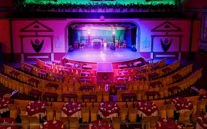 Stage setup at El Palacio Andaluz for a Flamenco show, featuring colorful seating and lighting.
