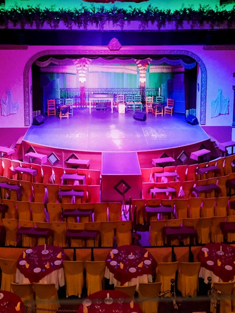 Stage setup at El Palacio Andaluz for a Flamenco show, featuring colorful seating and lighting.