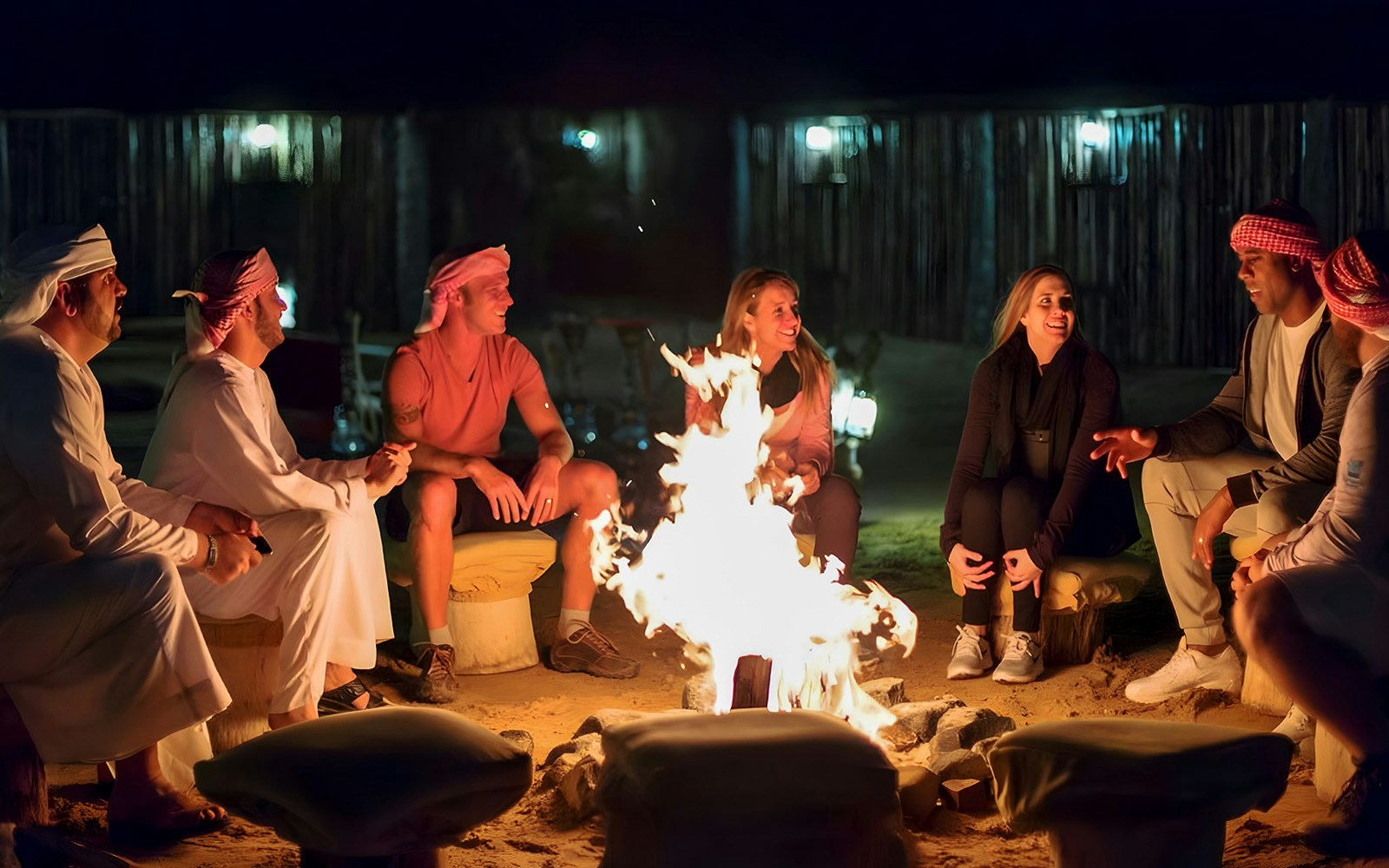 Group enjoying a campfire during an overnight desert stay, part of a premium hot air balloon experience.