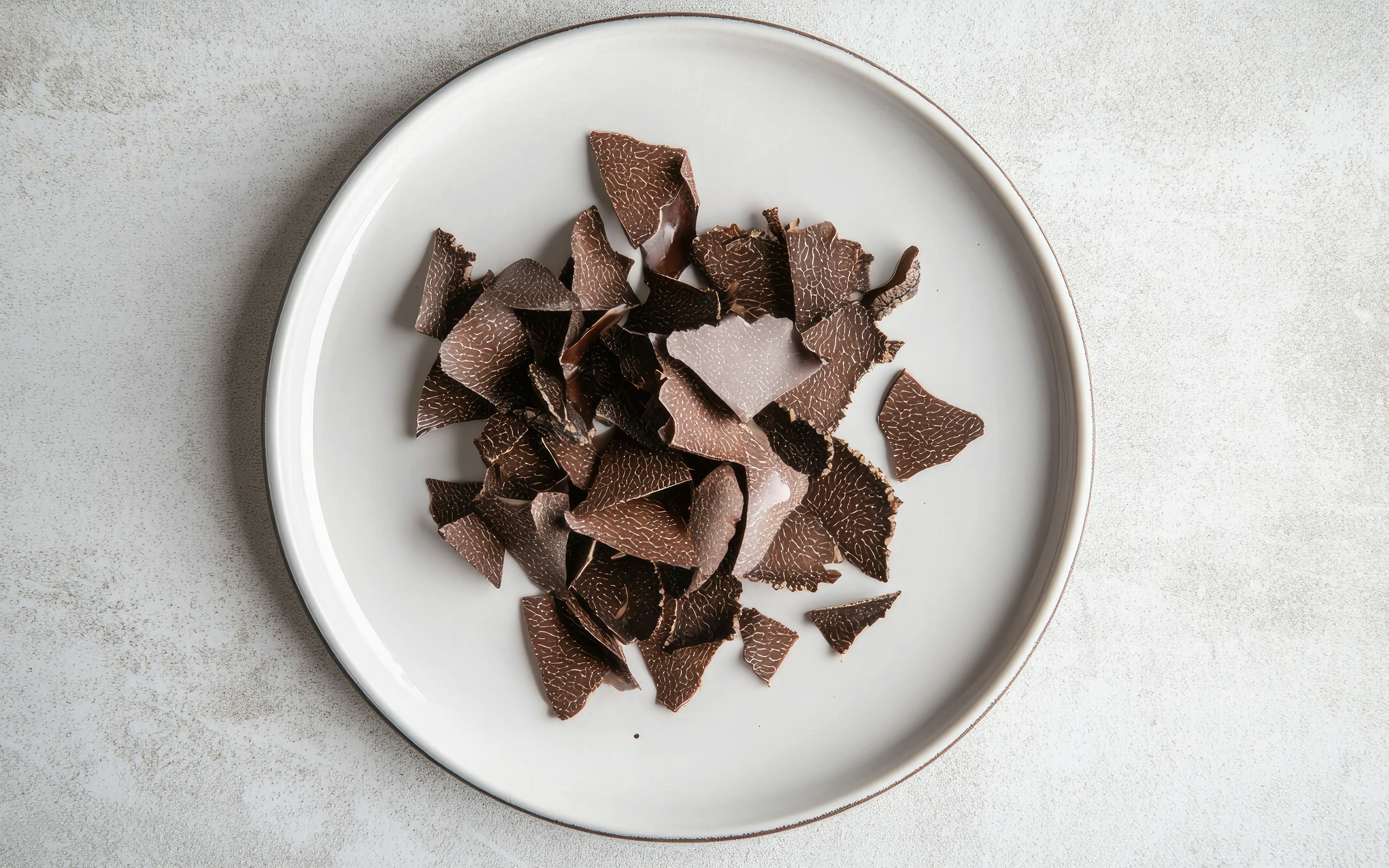 Truffle shavings on a white plate.