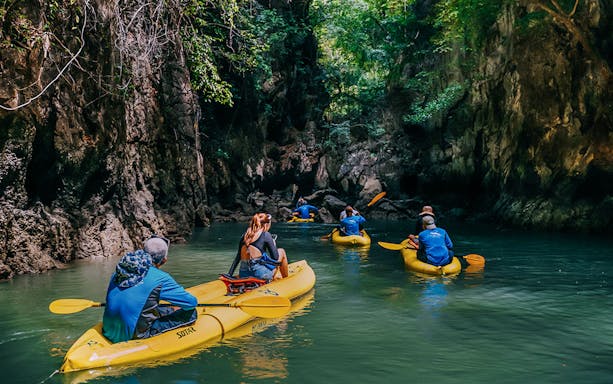 Kayakers exploring Panak Island's mangroves and caves in Thailand.