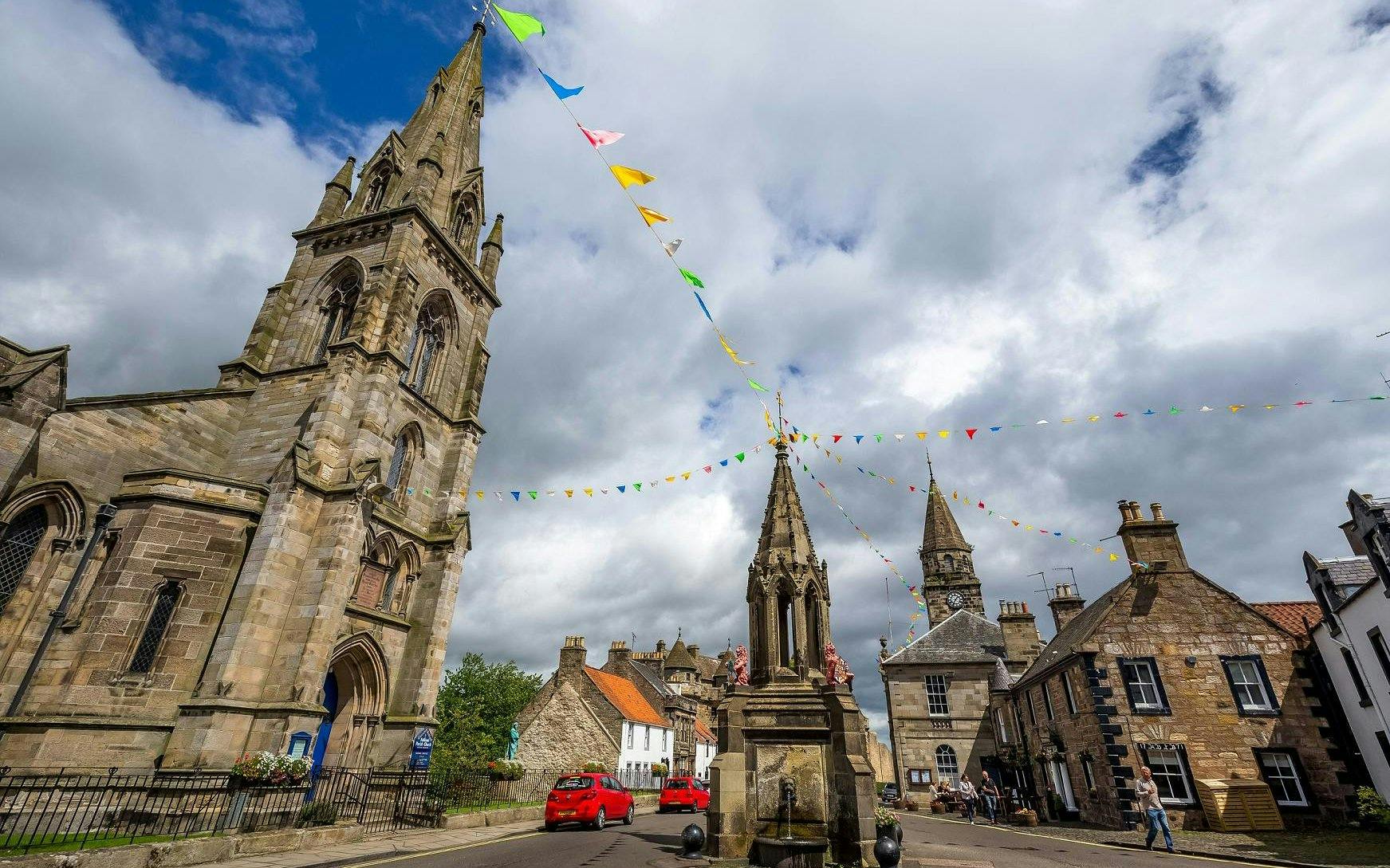 Historic Falkland village square with church and colorful bunting, Scotland.
