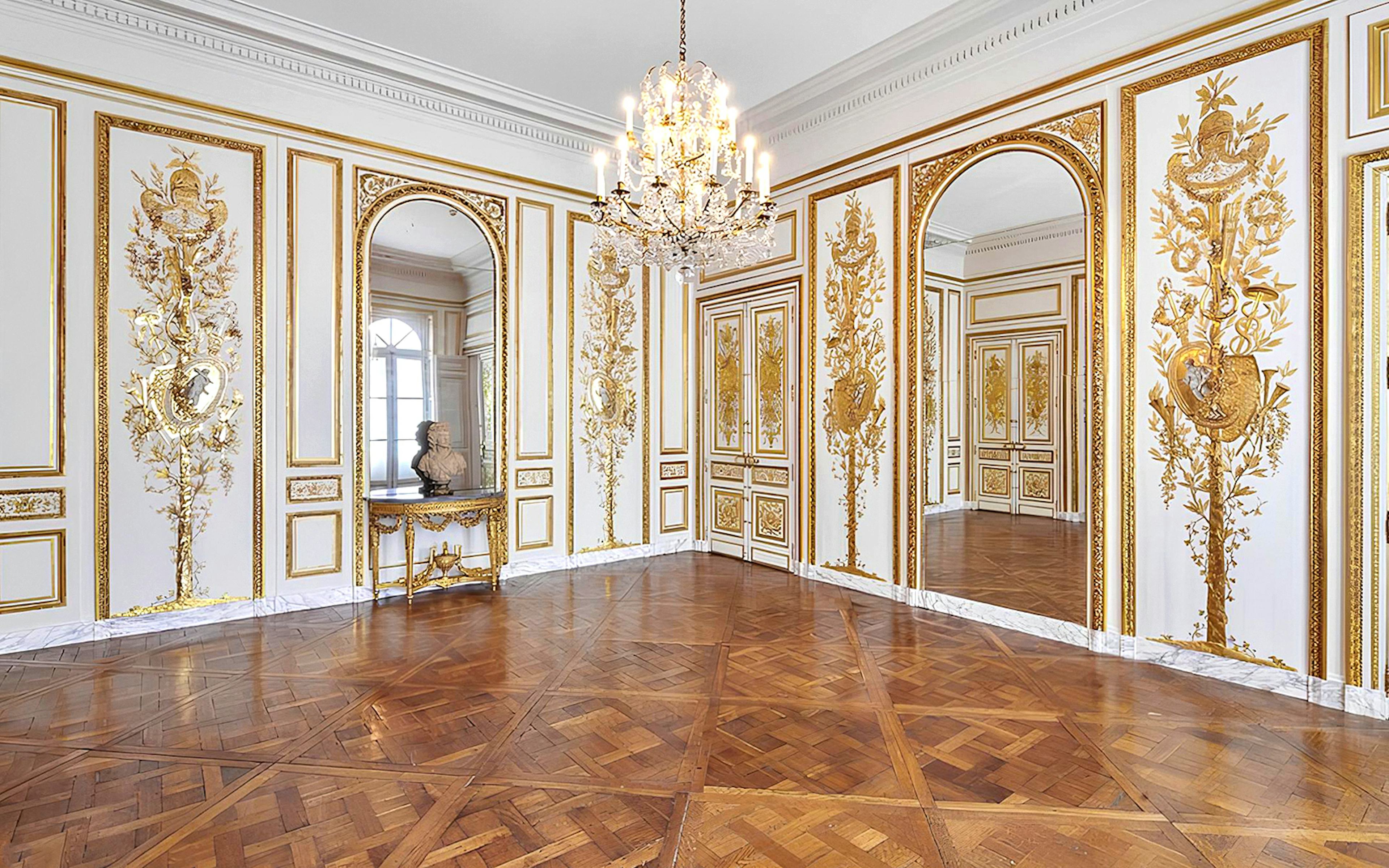 Elegant room with ornate gold detailing and chandelier at Carnavalet Museum, Paris.