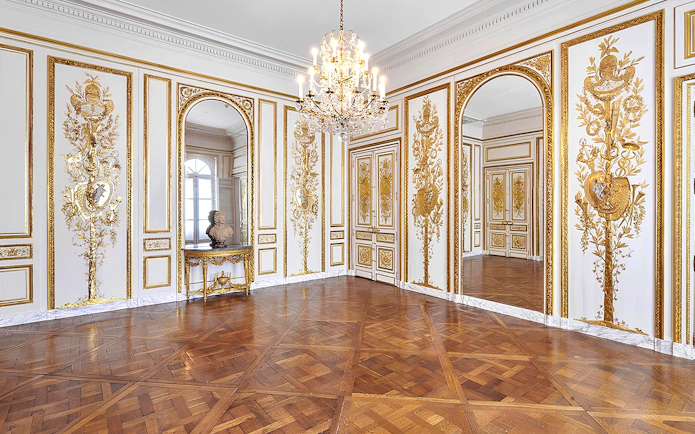 Elegant room with ornate gold detailing and chandelier at Carnavalet Museum, Paris.