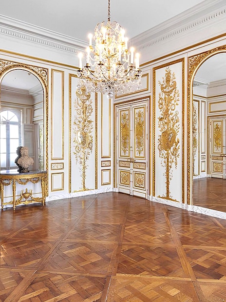 Elegant room with ornate gold detailing and chandelier at Carnavalet Museum, Paris.