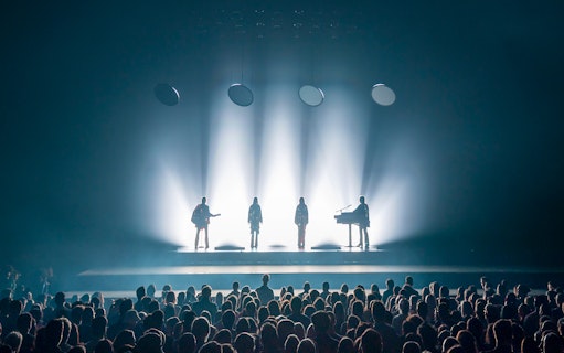 ABBA Voyage concert stage with band silhouettes and audience in London.