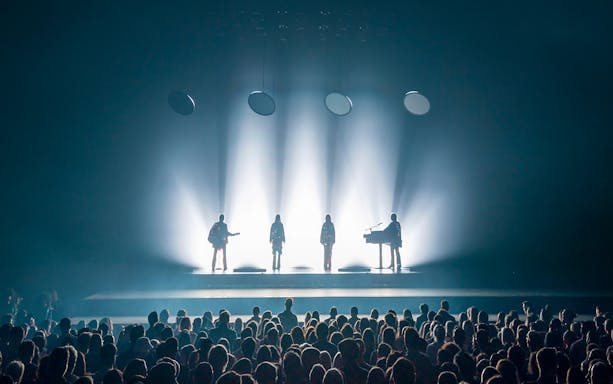 ABBA Voyage concert stage with band silhouettes and audience in London.