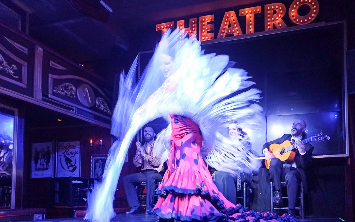 Flamenco dancer performing with musicians on stage at Esencia show.