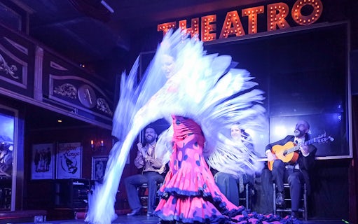 Flamenco dancer performing with musicians on stage at Esencia show.