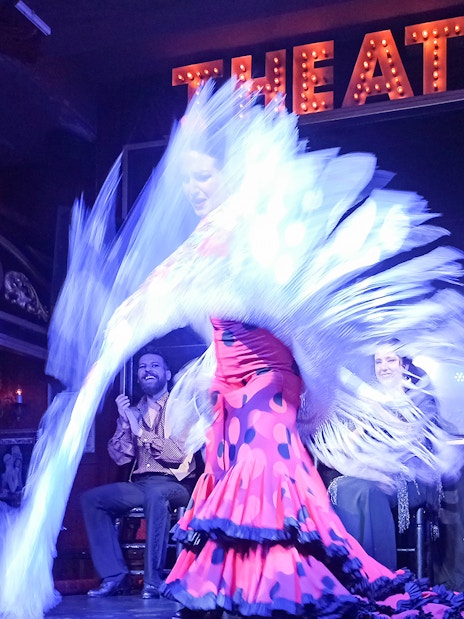 Flamenco dancer performing with musicians on stage at Esencia show.