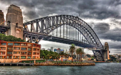 Sydney Harbour Bridge under cloudy sky, part of the True Crime Stories Guided Tour.