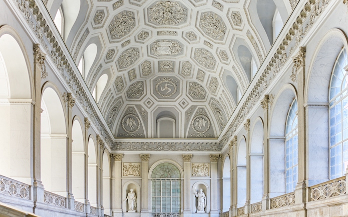 Ceiling and sculptures inside the Royal Palace of Naples, featuring ornate architectural details.