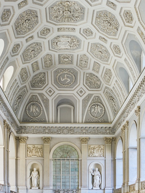 Ceiling and sculptures inside the Royal Palace of Naples, featuring ornate architectural details.