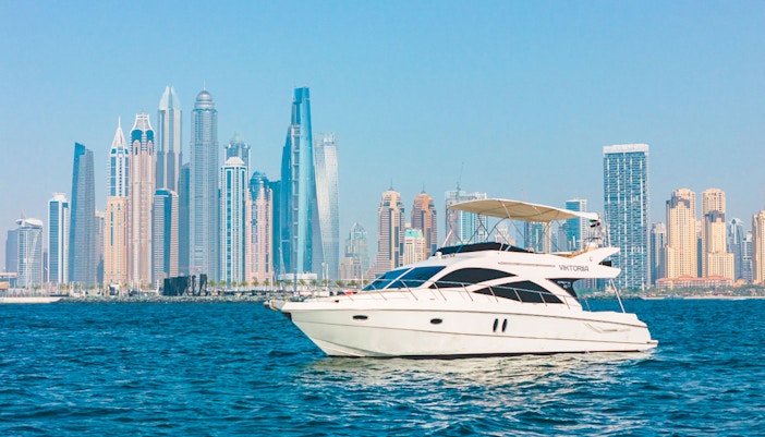 Yacht sailing with Dubai skyline in the background.