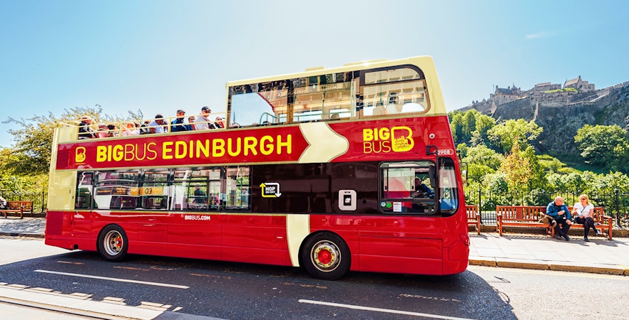 Edinburgh hop-on hop-off bus with Edinburgh Castle in the background.