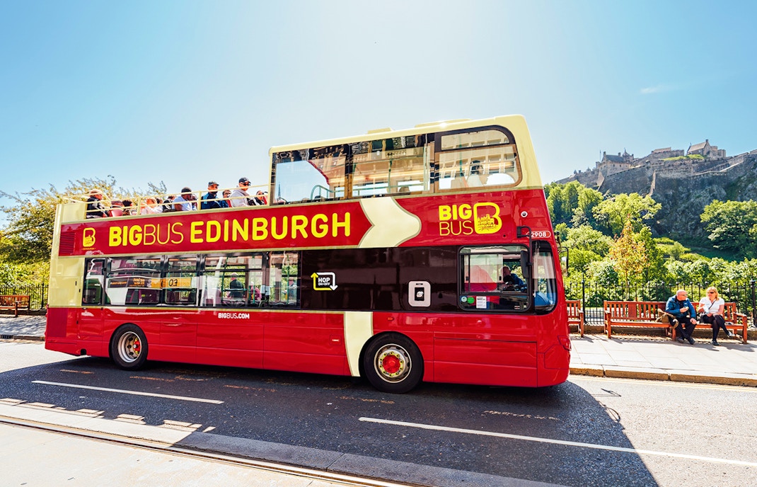 Edinburgh hop-on hop-off bus with Edinburgh Castle in the background.