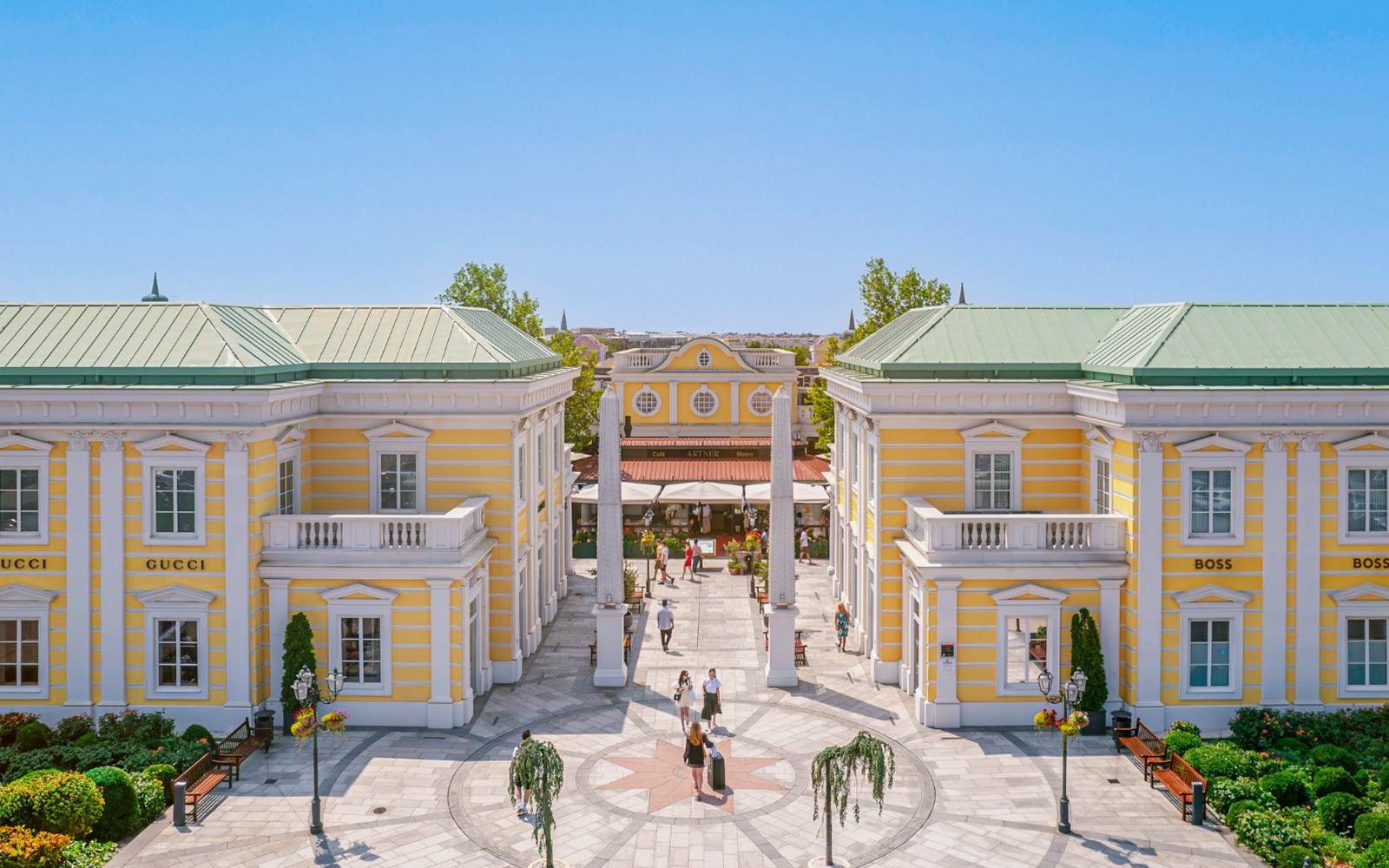 Parndorf Designer Outlet courtyard with shoppers near Budapest.
