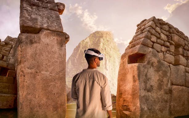 Man wearing VR headset exploring Machu Picchu ruins with mountain backdrop.