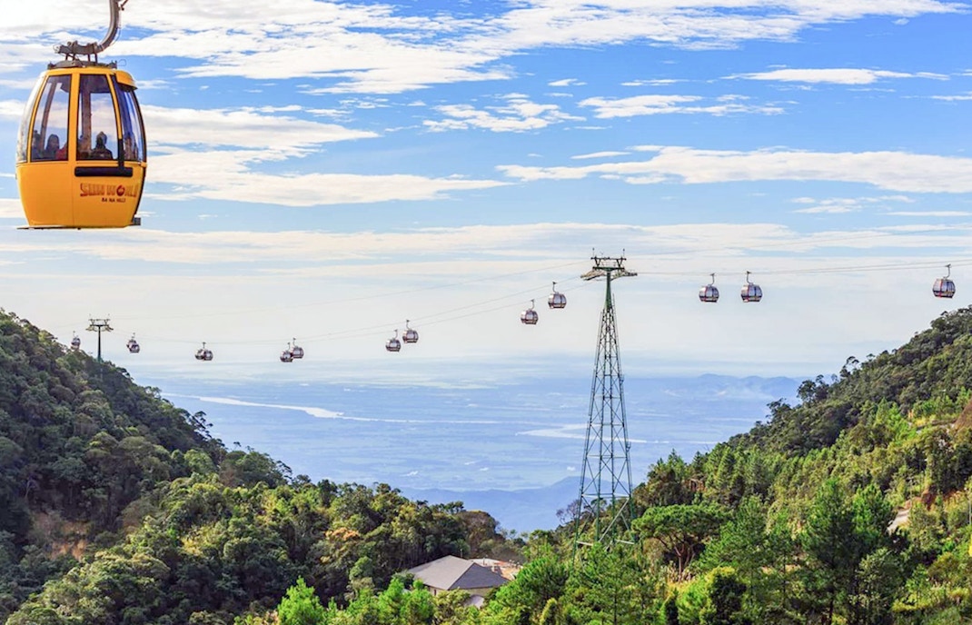 Sun World Ba Na Hills at night with illuminated Golden Bridge, buffet dinner setup, shuttle bus from Da Nang.