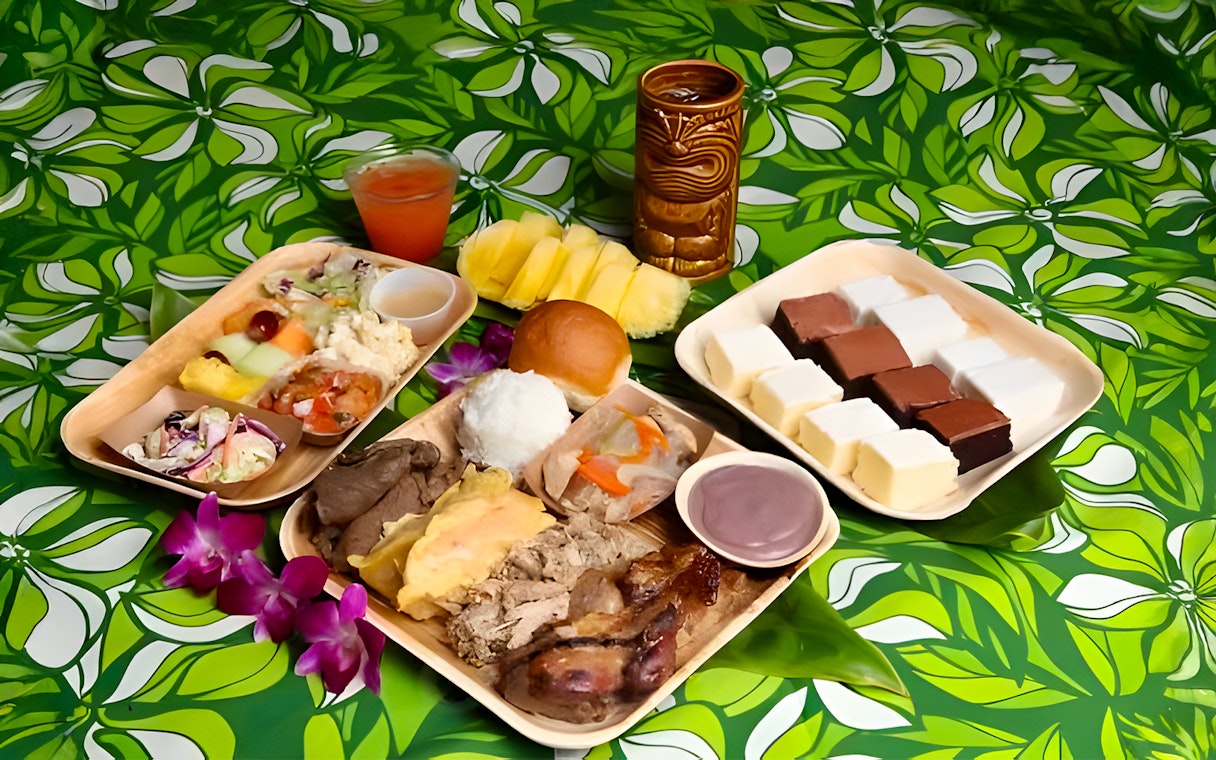 Traditional Polynesian cuisine platter at Germaine's Luau with meats, fruits, and desserts.