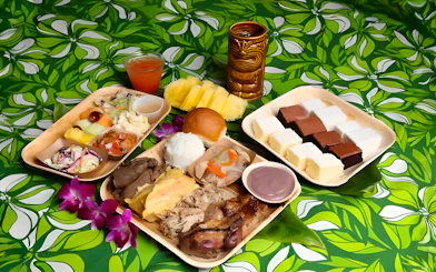 Traditional Polynesian cuisine platter at Germaine's Luau with meats, fruits, and desserts.