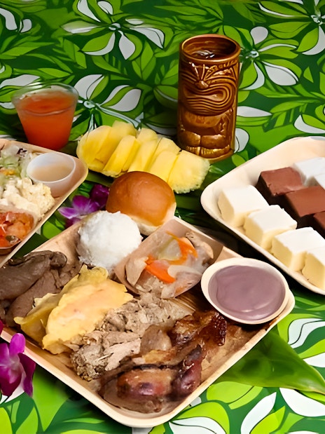 Traditional Polynesian cuisine platter at Germaine's Luau with meats, fruits, and desserts.
