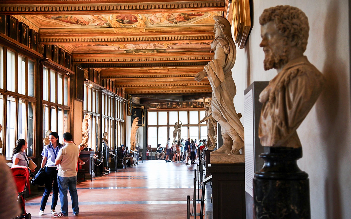 Visitors exploring statues in the Uffizi Gallery, Florence.