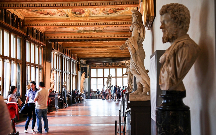 Visitors exploring statues in the Uffizi Gallery, Florence.