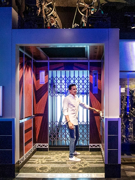 Male tourist entering elevator cab on 2nd floor of Empire State Building exhibition.
