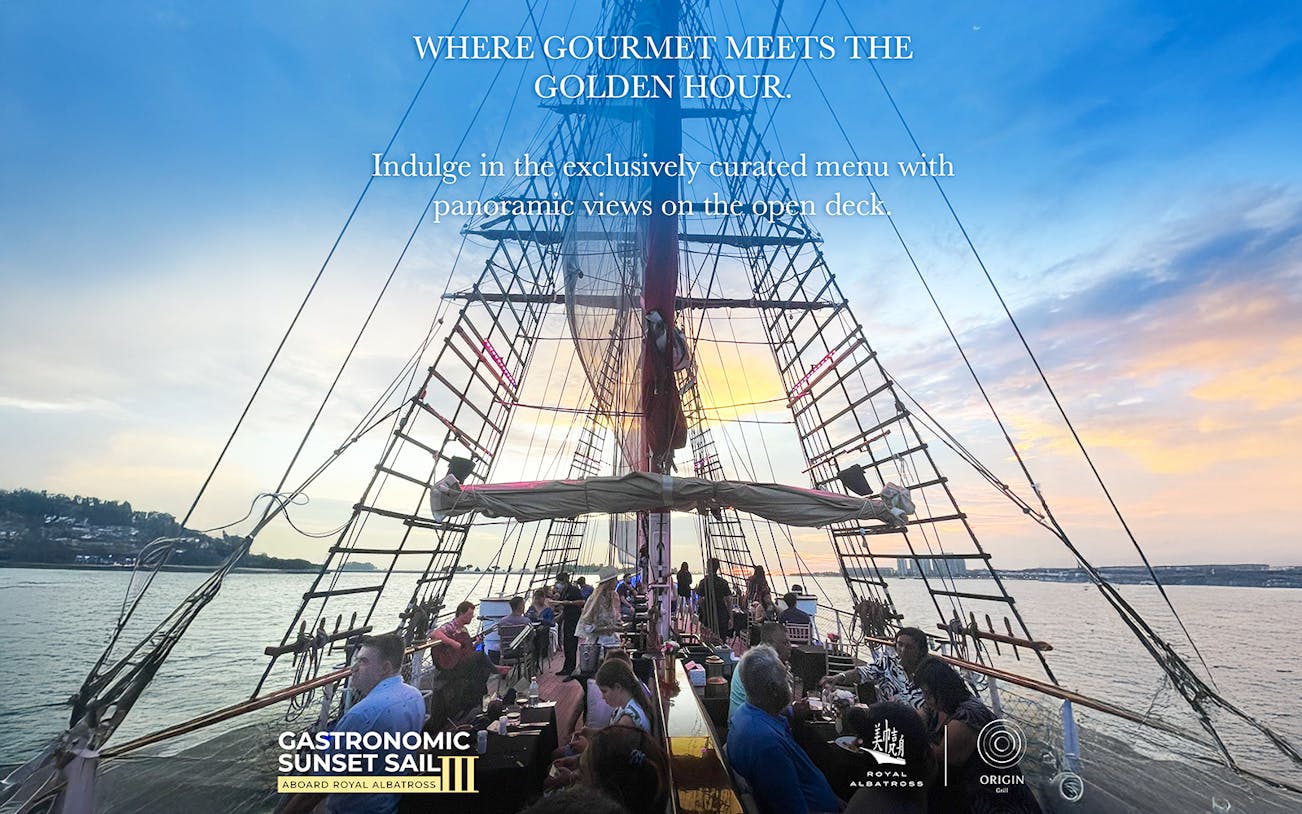 Dinner cruise on The Royal Albatross with guests dining on deck at sunset.
