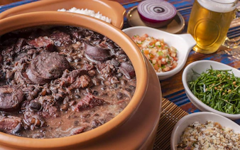 Feijoada dish with sides of rice, greens, and salsa on Rio de Janeiro food tour.