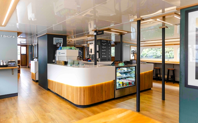 Interior of a ship's cafe area in Milford Sound, featuring seating and a refreshment counter.