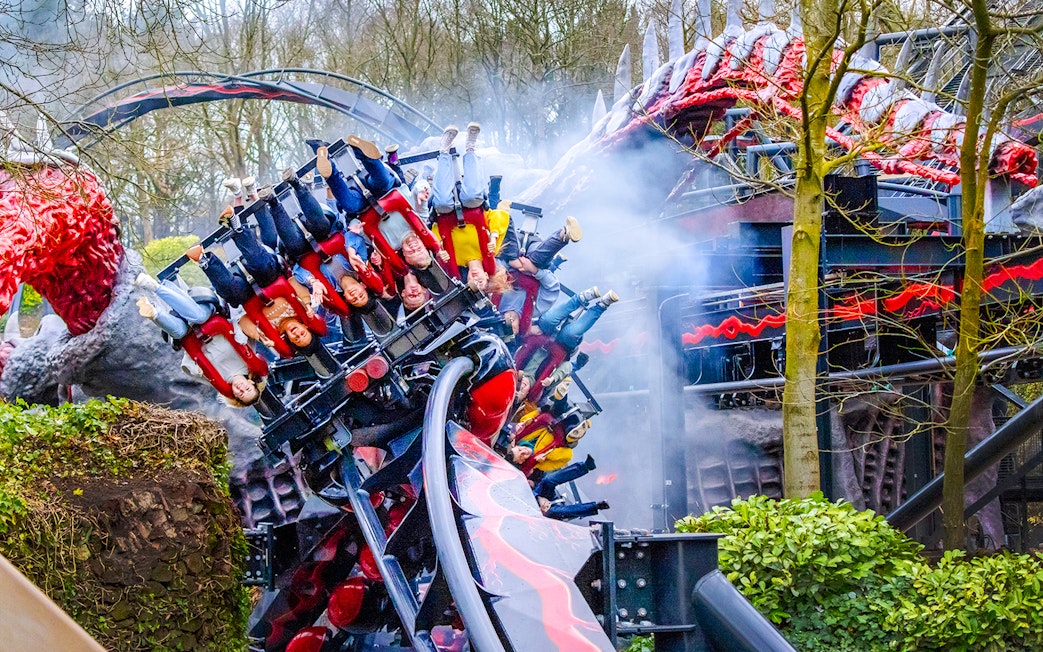 Riders on Nemesis Reborn roller coaster at Alton Towers, upside down on a loop.